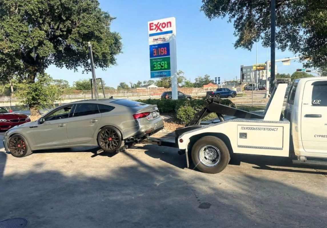 Roadside assistance in Houston technician fixing flat tire on highway