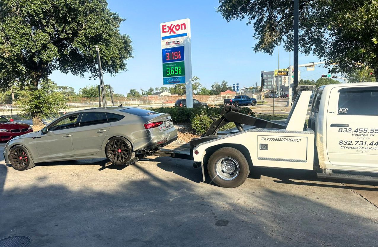 Roadside assistance in Houston technician fixing flat tire on highway