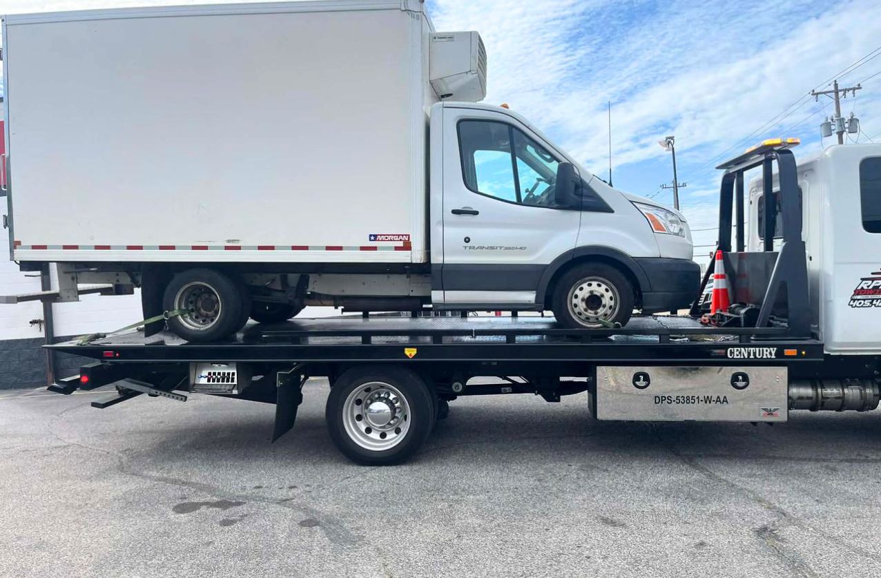 Heavy duty towing in Houston flatbed truck carrying a large black pickup