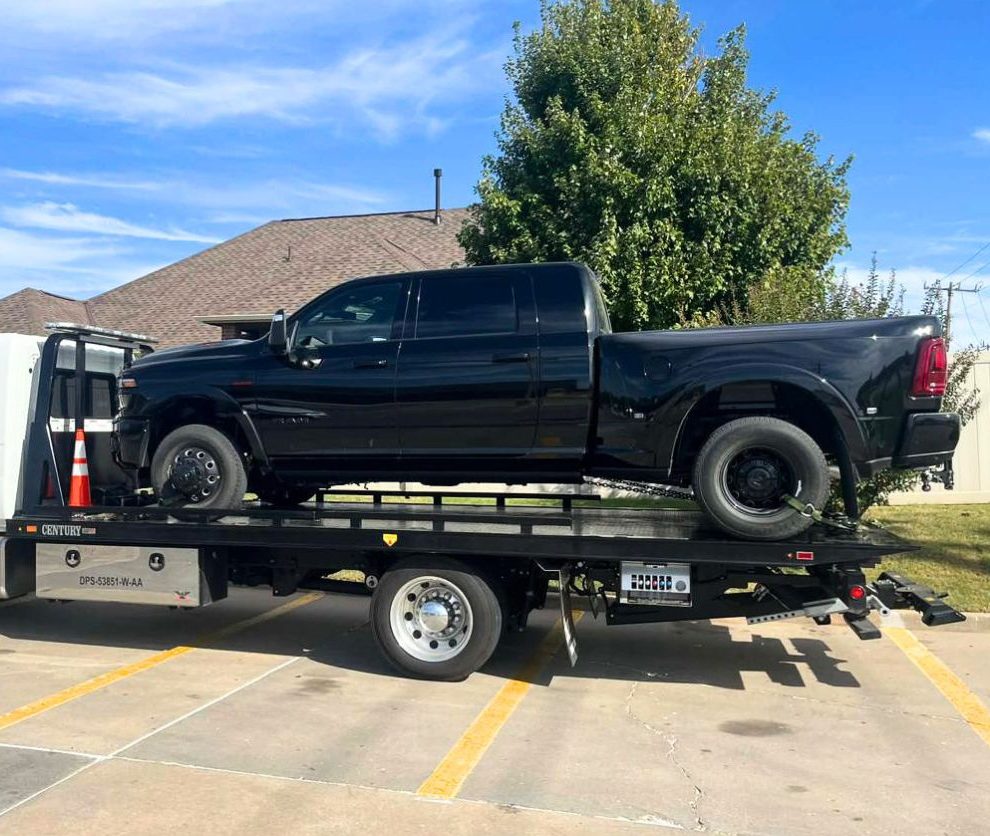 Heavy duty towing in Houston flatbed truck hauling a white pickup from an off-road field