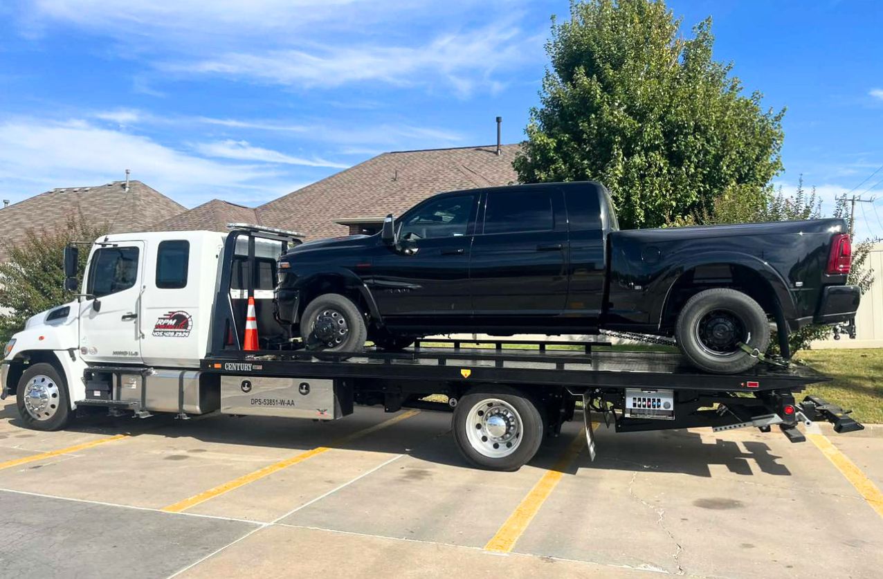 Heavy duty towing in Houston flatbed truck hauling a white pickup from an off-road field