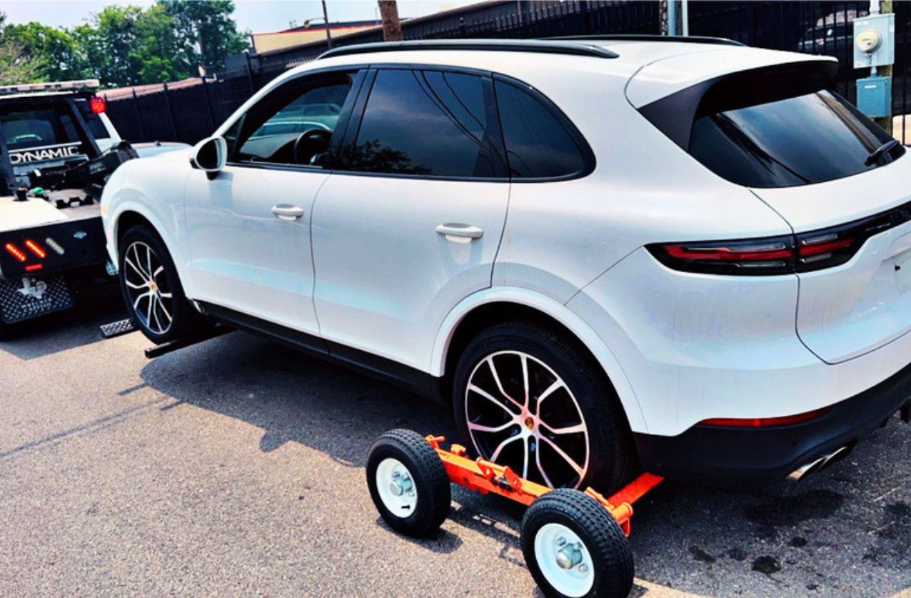 Tow truck service in Houston towing a white SUV with wheel lift and dollies